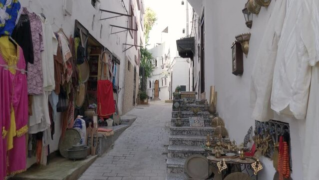 Static shot of tranquil narrow street with Clothes hanging outside a shop, Tangier, Morocco