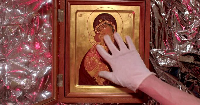 Icon theft at night, hands of a thief or robber. No face, gloved hands to avoid leaving fingerprints. Danger and caution are police flashing lights. Museum robbery. 