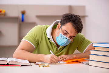 Young male student preparing for exams at home during pandemic