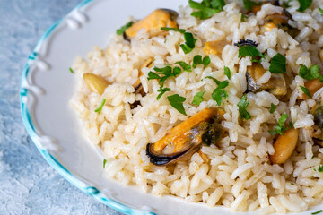 Mussel rice pilaf. Rice with mussels on small white plate on ceramic. (Turkish name; midyeli pilav)