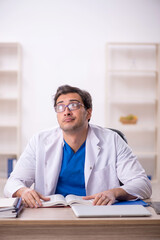 Young male doctor student reading book in the clinic