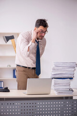 Young male employee unhappy with excessive work in the office