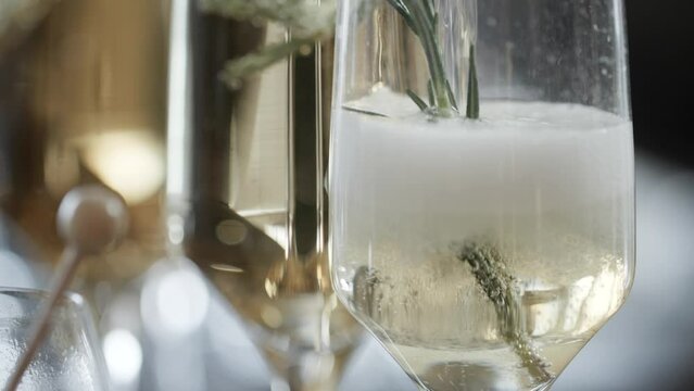 レモングラスを添えたグラスに注ぐシャンパン、スパークリングワイン　炭酸の泡　シュワシュワのマクロ・パーティー・お祝い・レストランのイメージ