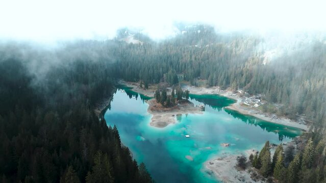 Aerial view of a pristine blue water lake Caumasee with forests and cloudsaround in Switzerland.