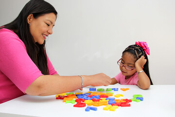 4-year-old Latina girl takes child therapy with the psychotherapist through games to treat her atuism and reflects emotions to learn about her cognitive abilities