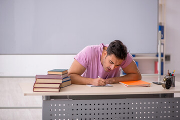 Fototapeta na wymiar Young male student preparing for exams in time management concep