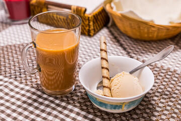 Cup of coffee and bowl of ice cream dessert on restaurant table