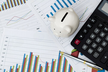 Piggy bank with calculator on the table