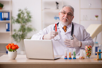 Old male doctor pharmacist working in the clinic