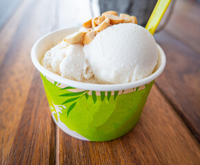 Coconut ice cream with nuts in green cup for take home.