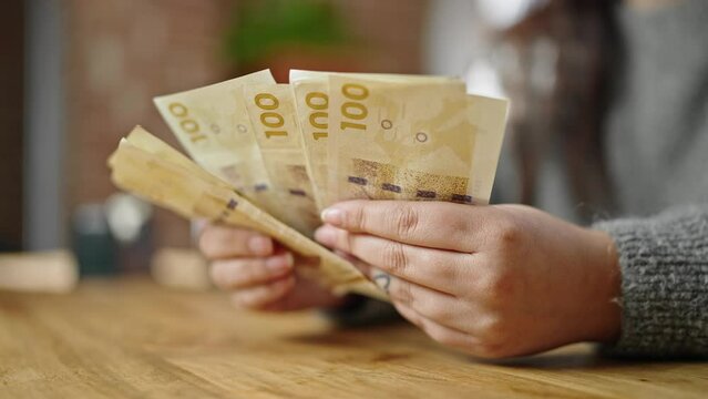 Hands of woman counting hundred denmark krone banknotes at room