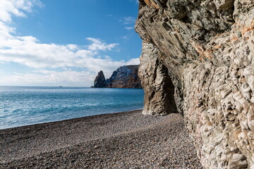 calm azure sea and volcanic rocky shores. Small waves on water surface in motion blur. Nature summer ocean sea beach background. Nobody. Holiday, vacation and travel concept