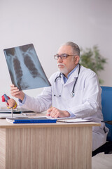 Old male doctor radiologist working at the hospital