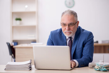 Old male employee working in the office