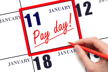 Hand writing text PAY DATE on calendar date January 11 and underline it. Payment due date