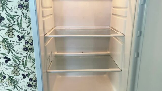 Opening empty fridge, hunger, job loss, unemployment, misery, financial collapse, economic crisis concept, starvation