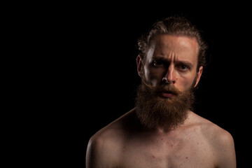 Fototapeta premium Portrait of cool bearded hipster on black background in studio photo. Expression and fashion
