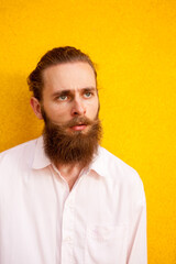 Tattooed bearded guy on yellow wall posing outdoor