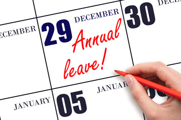 Hand writing the text ANNUAL LEAVE and drawing the sun on the calendar date December 29
