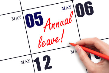 Hand writing the text ANNUAL LEAVE and drawing the sun on the calendar date May 5
