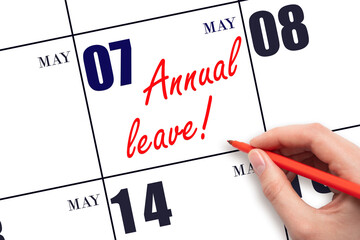 Hand writing the text ANNUAL LEAVE and drawing the sun on the calendar date May 7