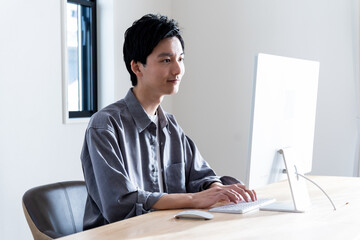 PC作業をする若い日本人男性