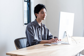 PC作業をする若い日本人男性