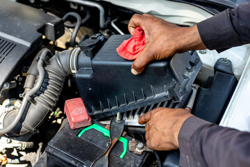 Fototapeta na wymiar Technician holding and cleaning dirty air filter of a vehicle