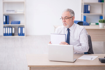 Old male employee working in the office