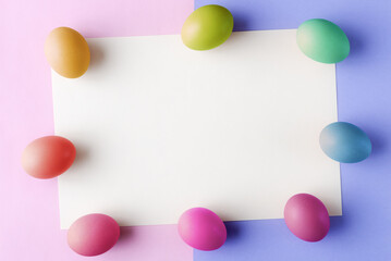 Painted Easter eggs on blank light yellow background with copy space. Easter greeting card template