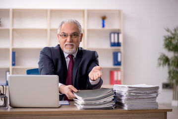 Obraz premium Old male employee sitting at workplace