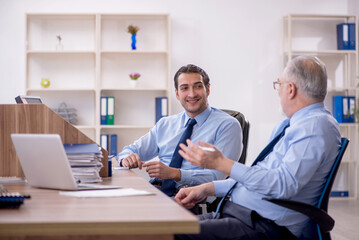 Obraz premium Two male colleagues working in the office