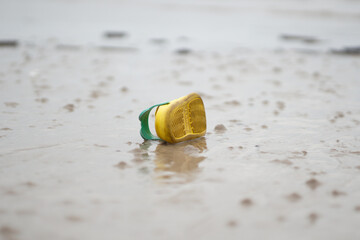 child drowned on the beach. A photo of a yellow sandal on the beach like an illustration of a drowning child
