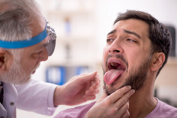 Young male patient visiting old male doctor otologist