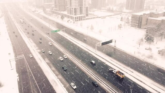 Aerial, traffic driving on highway during a blizzard snow storm in Canada