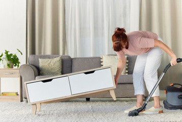 Woman, vacuum and housekeeping on carpet in living room for spring cleaning service, dust or dirt...