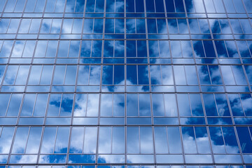 Obraz premium ガラス張りの建物に映る白い雲