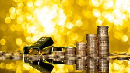 Gold bars and coins on shiny background