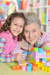 Cute girl and grandmother playing