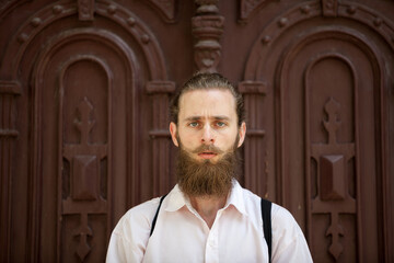 Portrait of bearded hipster in front of a door. Style and diversity