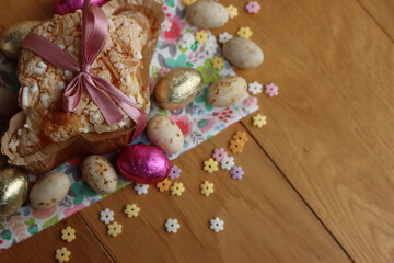 Naklejka na ściany i meble Colomba Pasquale. Sweet Easter cake with chocolate eggs on floral fabric . Italian traditional pastry on wooden table