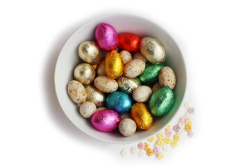 Chocolate Easter eggs wrapped in bright multicolored foil isolated on white background