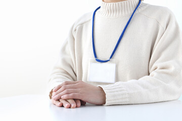 会議・研修に参加するネームホルダーを付けた私服の女性