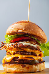 Loaded cheeseburgers three triple, stacked patties stacked high with layers of cheese, lettuce, and tomato. Tall cheeseburger. High quality photo