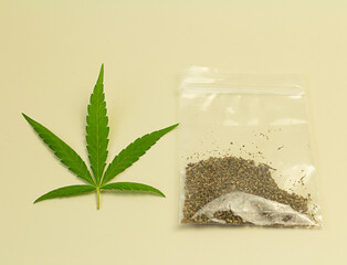 Cannabis leaf with a plastic bag for crushed cannabis