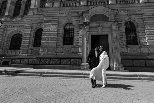 International couple kissing. Indian groom. Street wedding photo shooting.