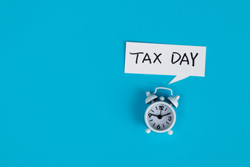 Alarm clock with tax day text - obrazy, fototapety, plakaty