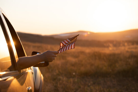 Man`s hand holding a waving american USA flag.