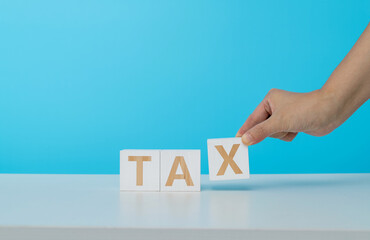 People hand holding wooden blocks with tax