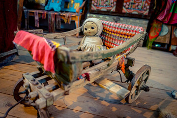 Creepy baby girl doll in a cradle on wheels